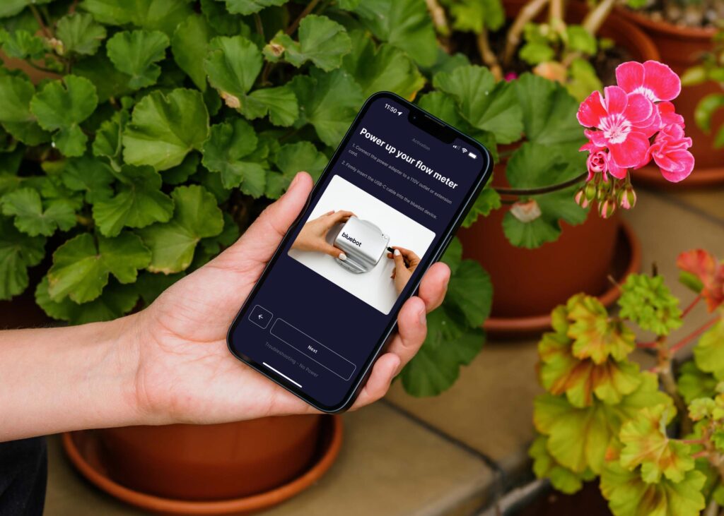 Mockuuups Female Hand Holding An Iphone 13 Mockup In Garden Place 1024x731